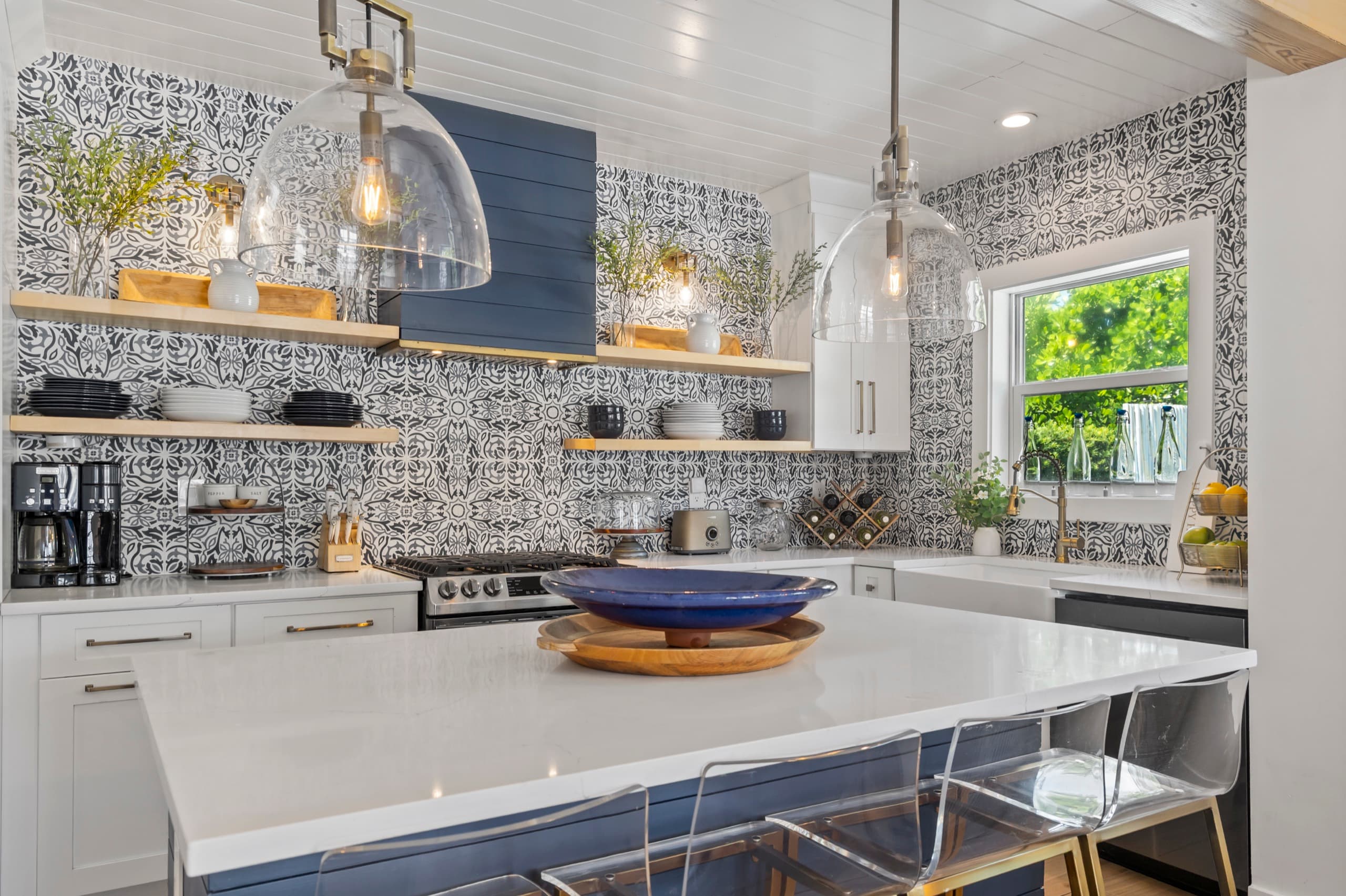 Fully equipped kitchen with a large island, gas range, and designer tile